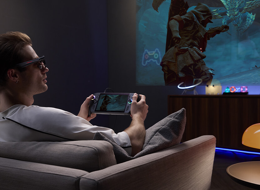Мужчина играет в Monster Hunter в игровых AR-очках ROG R1 на контроллерах за своим игровым ПК-сетапом
